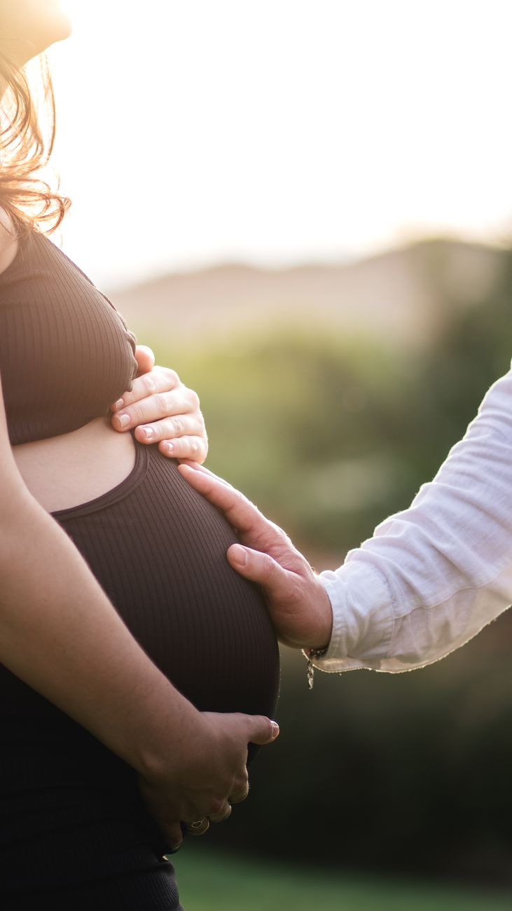 man hand on pregnant woman abdomen